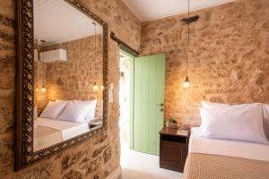 a bedroom with two beds and a mirror at Amalthea Guest House in Egina