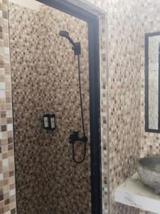 a shower with a shower head in a bathroom at Relaxing Homestay & Hostel in Kuta Lombok