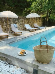 a bowl of fruit on a plate next to a swimming pool at Le Pont de L'orme in Malaucène