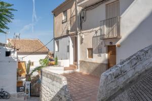 Eine Gasse zwischen zwei weißen Gebäuden mit einem Zaun in der Unterkunft Calma Cazorla in Cazorla