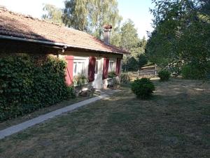 a red house with a yard next to a building at B&B Les Paddocks in Vollore-Montagne