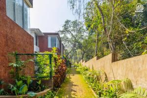 a path through a garden next to a building at SolVanya by evaddo stays 2BHK Luxury Villa with Private Pool in Siolim in Siolim +36 photos