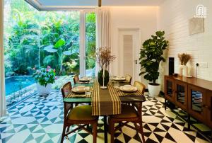 a dining room with a table and chairs and a large window at SolVanya by evaddo stays 2BHK Luxury Villa with Private Pool in Siolim in Siolim