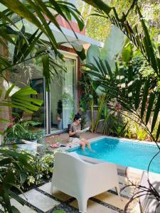 a man sitting by a swimming pool in a garden at SolVanya by evaddo stays 2BHK Luxury Villa with Private Pool in Siolim in Siolim