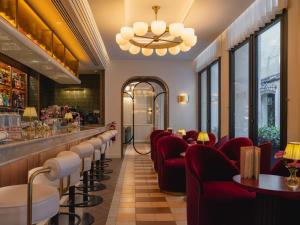 a restaurant with red chairs and a bar at Hotel Condal in Barcelona