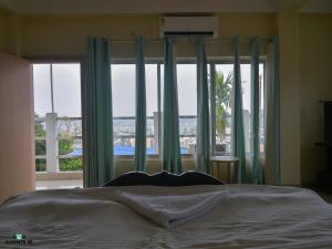a bedroom with a bed and a large window at Genesis villa in Guwahati