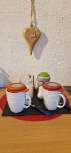 a group of cups and utensils on a table at Chambre d'Hotes Le Vogelgarten in Sigolsheim