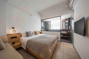 a bedroom with a bed and a tv and a couch at JIDMI HOTEL in Xiamen