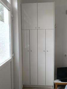 a white cabinet in a room with a window at Zadar Sunhouse Studio with Terrace in Zadar