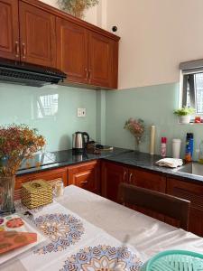 a kitchen with wooden cabinets and a table with a tablecloth at House 1994 in Xuan An