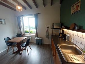 a kitchen with a sink and a table and a window at B&B Les Paddocks in Vollore-Montagne +17 photos