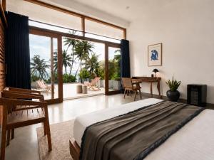 a bedroom with a bed and a view of a patio at Chez Colette in Matara