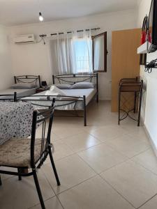 a room with three beds and a chair in it at Joni's house in Piqeras