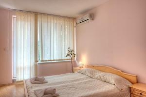 a bedroom with a bed and a large window at Privilege Beach Apartments in Sveti Vlas +42 photos