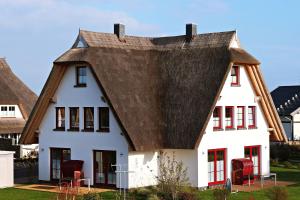 a large white house with a thatched roof at Seeperle in Dranske +10 photos