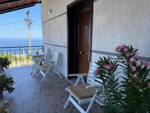 a balcony with chairs and a table and a door at Joni's house in Piqeras