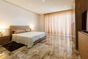 a bedroom with a bed and a flat screen tv at Bayleaf Coastal Apartment in Marsaxlokk