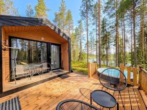 a cabin with a deck with chairs and a table at Villa Kutula in Hossa