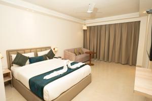 a bedroom with a large bed and a chair at Tirupati Resorts in Kota