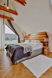 a bedroom with a bed and a large window at Loftowe Zacisze in Bystra