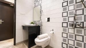 a white bathroom with a toilet and a sink at BluO Lake View NewTown - Boutique Hotel in Kolkata +33 photos