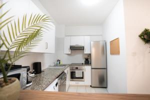 a kitchen with white cabinets and a stainless steel refrigerator at Cozy Apartment in Paphos Beautiful Complex in Paphos
