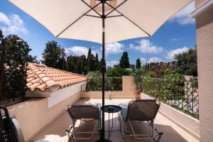 a patio with a table and chairs and an umbrella at Cozy Apartment in Paphos Beautiful Complex in Paphos
