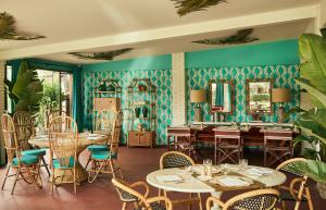 a restaurant with tables and chairs and green walls at Hermitage Hotel & Resort Forte dei Marmi - Starhotels Collezione in Forte dei Marmi