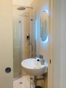 a white bathroom with a sink and a shower at Antigua 22 in Monopoli +30 photos