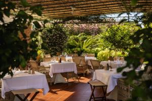a restaurant with white tables and chairs and plants at Hermitage Hotel & Resort Forte dei Marmi - Starhotels Collezione in Forte dei Marmi +119 photos