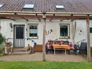 a patio with a table and chairs in front of a house at Hennickes Fewo in Friedrichshof