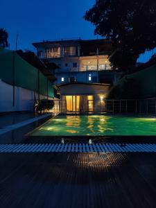 an empty swimming pool in front of a building at night at Genesis villa in Guwahati