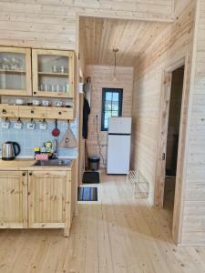 a kitchen with wooden cabinets and a refrigerator at Cottage in Tskhvarichamia forest 2 in Tsʼkhvarichamia