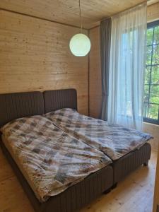 a bed in a room with a large window at Cottage in Tskhvarichamia forest 2 in Tsʼkhvarichamia