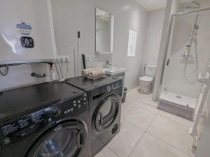 a washing machine in a bathroom with a toilet at Le Petit Forez, Cosy et Authentique in Saint-Bonnet-le-Château +5 photos