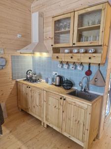 a kitchen with wooden cabinets and a sink at Cottage in Tskhvarichamia forest 2 in Tsʼkhvarichamia +14 photos