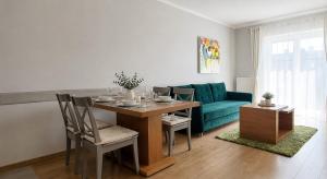 a living room with a table and a blue couch at Apartament Fabryczna TK in Namysłów