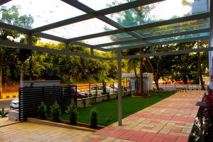 una pérgola con una pasarela de ladrillo y césped en Villa Park, en Mysore