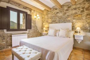 a bedroom with a bed and a stone wall at Cal Potret in Argençola +27 photos