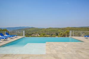 a swimming pool with chairs and a view of the mountains at Cal Potret in Argençola