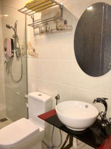 a bathroom with a sink and a toilet and a mirror at Elmark Hotel Kuantan in Kuantan