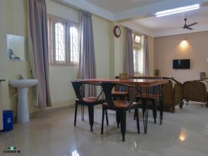 a dining room with a wooden table and chairs at Genesis villa in Guwahati