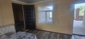 an empty room with a window and a bed in it at Amir Guesthouse in Chon-Dzhargylchak