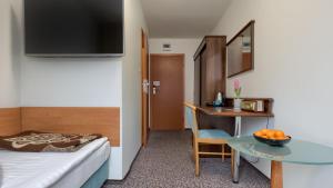 a room with a bed and a table with a bowl of fruit at Jantar Resort in Szczecin