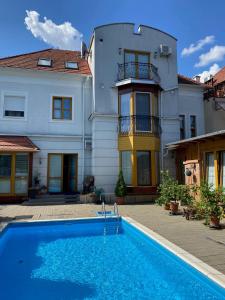 a house with a swimming pool in front of a house at Platán Hotel in Sárvár