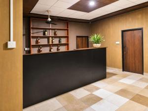 a lobby with a black counter with a potted plant at Vegas Nature Resort in Dankotuwa