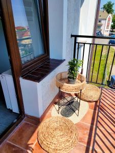a balcony with two tables and a potted plant at Lyck Aparthotel in Ełk