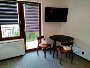 a room with a table and two chairs and a television at Lyck Aparthotel in Ełk