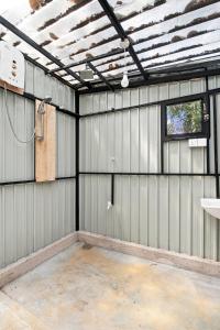 an empty metal garage with a window and a ceiling at Jungle Nest Ella in Ella