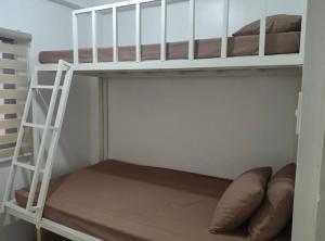 a bunk bed in a small room with a ladder at DVM Transient Inn by RedDoorz in Santo Tomas